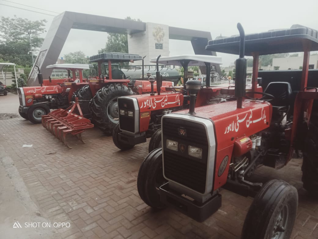 PLC branded tractors at main gate — maintenance fleet