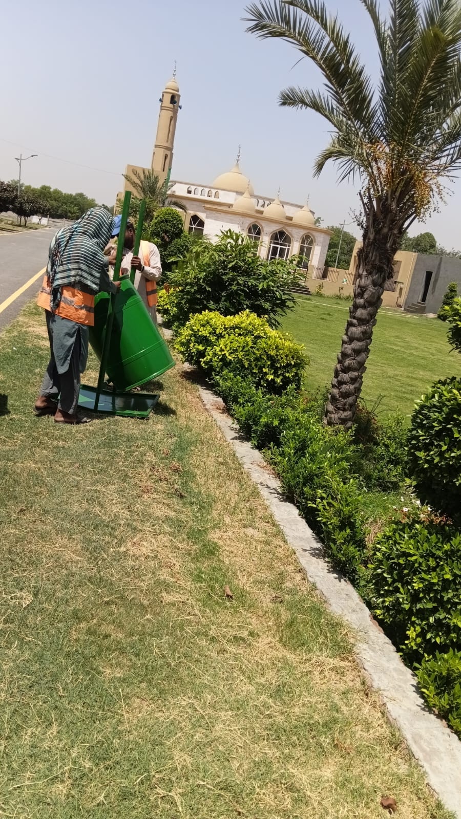 PLC grounds staff collecting waste in the mosque garden